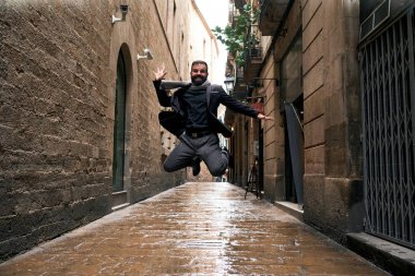 Bir adam şehir sahnesinde ıslak zeminde atlar