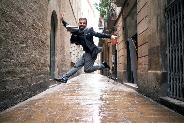 Bir adam şehir sahnesinde ıslak zeminde atlar