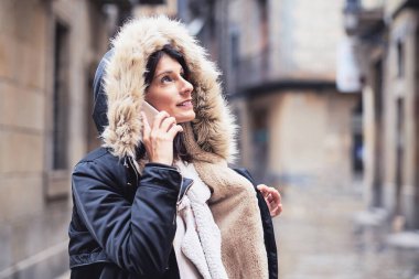 yağmurlu bir kış gününde paltosu olan genç bir kadın