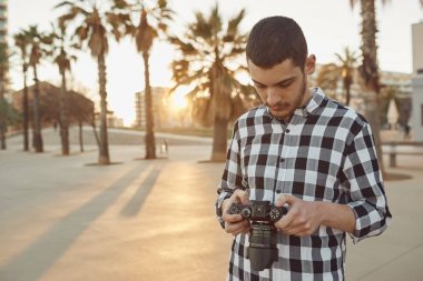 gün batımında bir vintage kamera ile genç bir fotoğrafçı