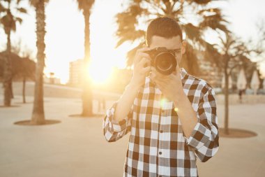 gün batımında bir vintage kamera ile genç bir fotoğrafçı