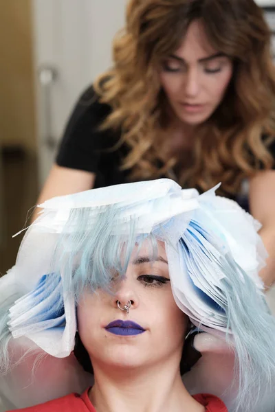En frisör på skönhetssalongen med kunder — Stockfoto