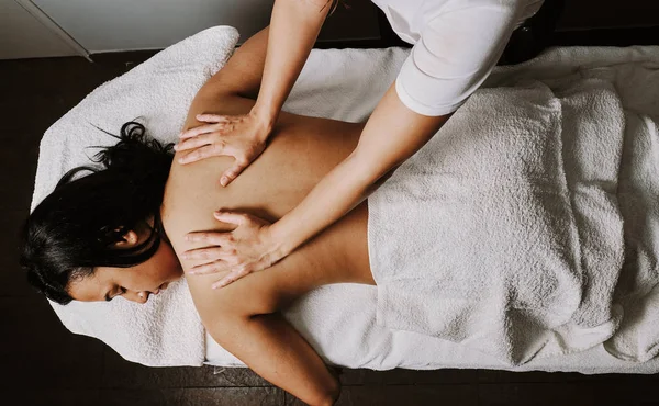 close-up masseur hands doing back massage in spa center
