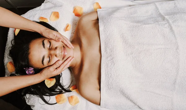 Joven mujer afroamericana recibiendo un masaje facial y de cabeza — Foto de Stock