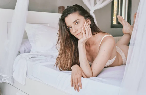 Une jeune femme sexy en sous-vêtements sur son lit — Photo