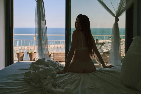 Ein junges Model in Unterwäsche sitzt vor einem Fenster — Stockfoto