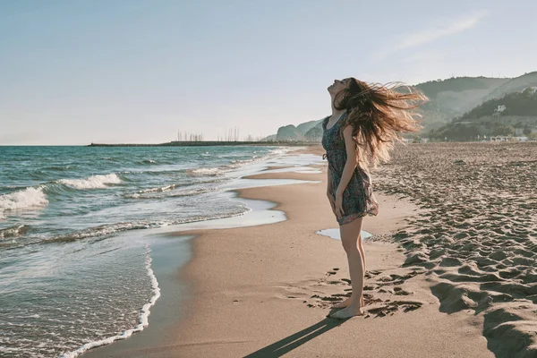 Een gelukkige jonge vrouw op het strand — Stockfoto