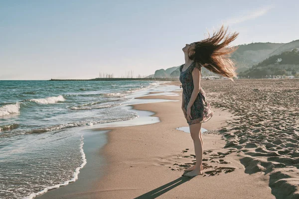 Een gelukkige jonge vrouw op het strand — Stockfoto