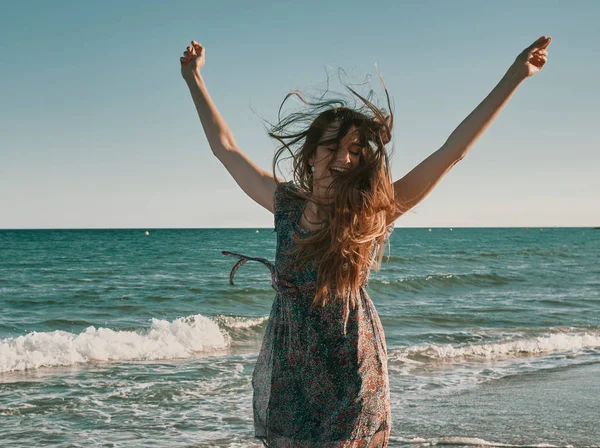 Μια ευτυχισμένη νεαρή γυναίκα στην παραλία — Φωτογραφία Αρχείου