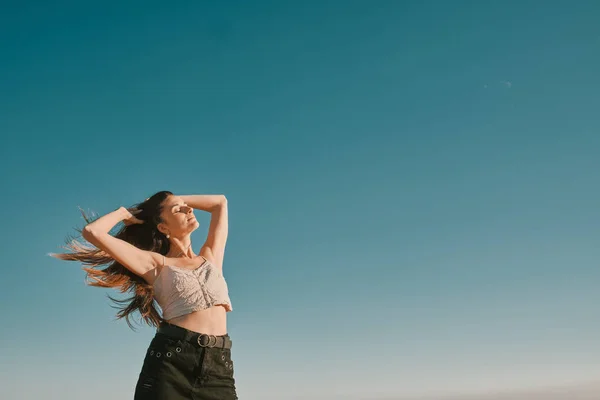 Una giovane donna in un giorno d'estate con un cielo blu - spazio negativo — Foto Stock