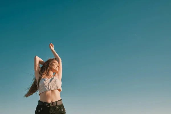 Een jonge vrouw in een zomerdag met een blauwe hemel-negatieve ruimte — Stockfoto