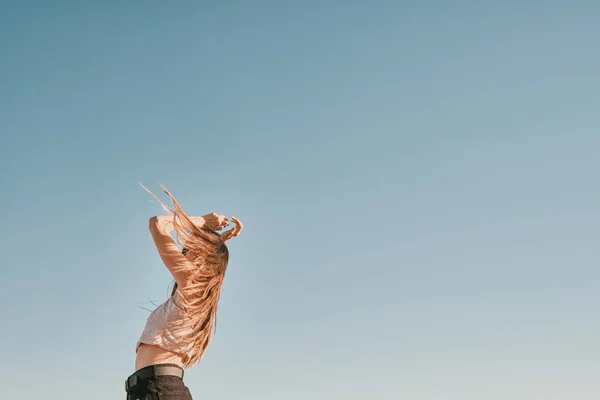 Une jeune femme dans un jour d'été avec un ciel bleu - espace négatif — Photo