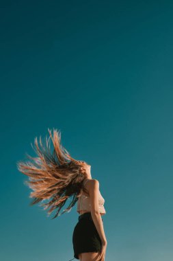 mavi bir gökyüzü ile bir yaz gününde genç bir kadın - negatif alan