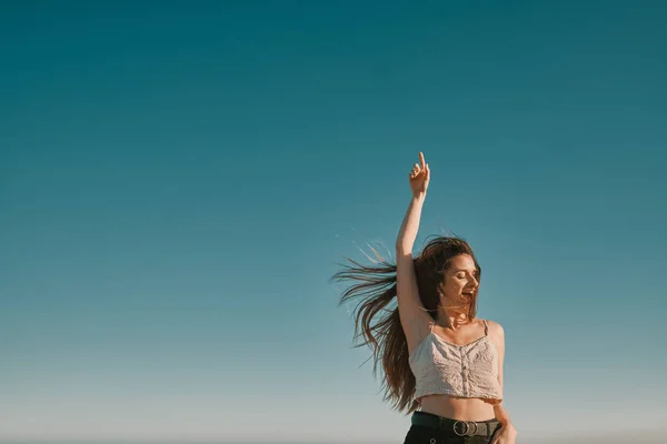 Een jonge vrouw in een zomerdag met een blauwe hemel-negatieve ruimte — Stockfoto