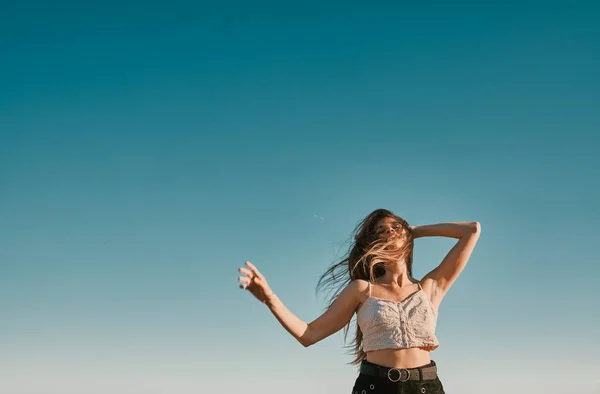 Een jonge vrouw in een zomerdag met een blauwe hemel-negatieve ruimte — Stockfoto