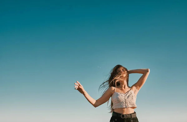 Una mujer joven en un día de verano con un cielo azul - espacio negativo —  Fotos de Stock