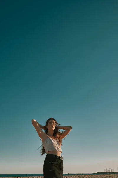 Μια νεαρή γυναίκα σε μια καλοκαιρινή μέρα με ένα γαλάζιο ουρανό-αρνητικό χώρο — Φωτογραφία Αρχείου