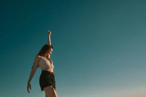 Een jonge vrouw in een zomerdag met een blauwe hemel-negatieve ruimte — Stockfoto