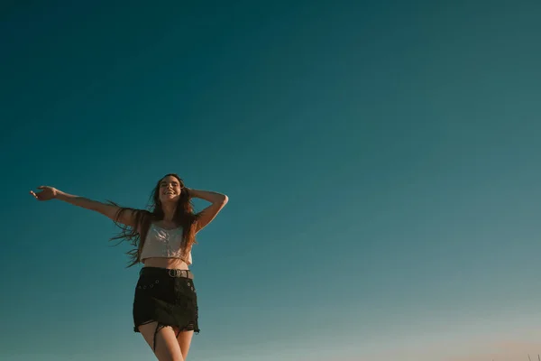 Een jonge vrouw in een zomerdag met een blauwe hemel-negatieve ruimte — Stockfoto