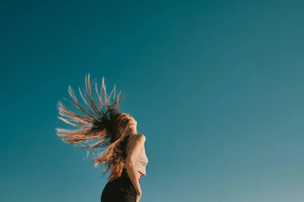 Een jonge vrouw in een zomerdag met een blauwe hemel-negatieve ruimte — Stockfoto