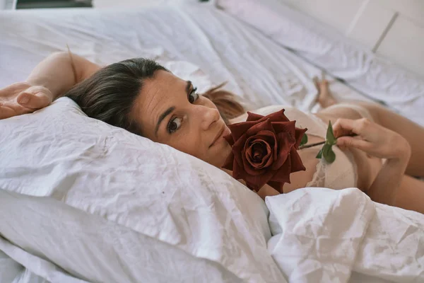 Een jonge sexy vrouw met een roos in ondergoed — Stockfoto