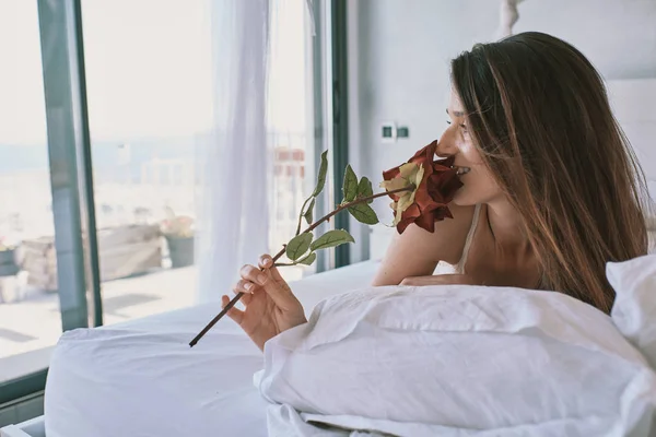 Eine junge sexy Frau mit einer Rose in Unterwäsche — Stockfoto
