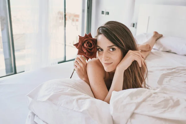 Een jonge sexy vrouw met een roos in ondergoed — Stockfoto