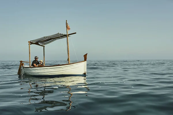 Um pai e um filho navegando em um clássico barco vintage — Fotografia de Stock