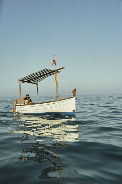 a father and a son sailing in a classic vintage boat
