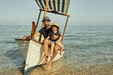 yaz aylarında klasik bir teknede baba ve oğlu