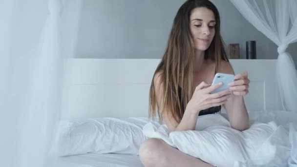 Μια Νεαρή Γυναίκα Εσώρουχα Στο Κρεβάτι Της Χρησιμοποιώντας Κινητό Της — Αρχείο Βίντεο
