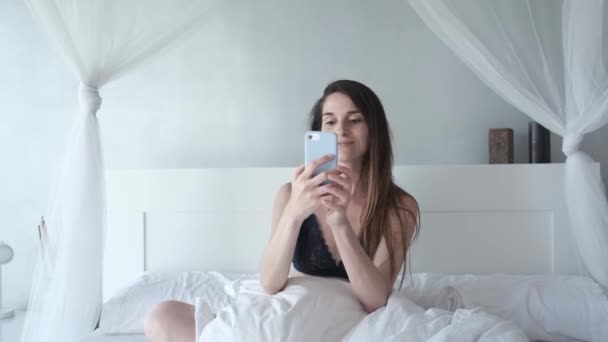 Een Jonge Vrouw Ondergoed Haar Bed Met Behulp Van Haar — Stockvideo