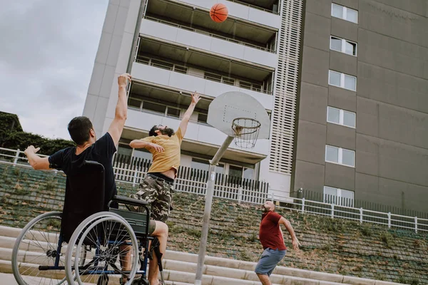 En man i rullstol spelar korg med vänner — Stockfoto