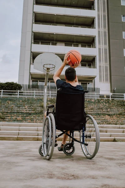 a man in wheelchair plays basketball