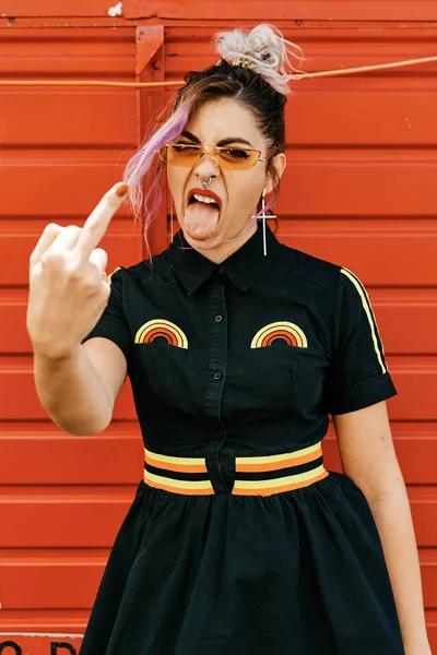 girl showing middle finger, alternative model with middle finger lifted - woman power concept