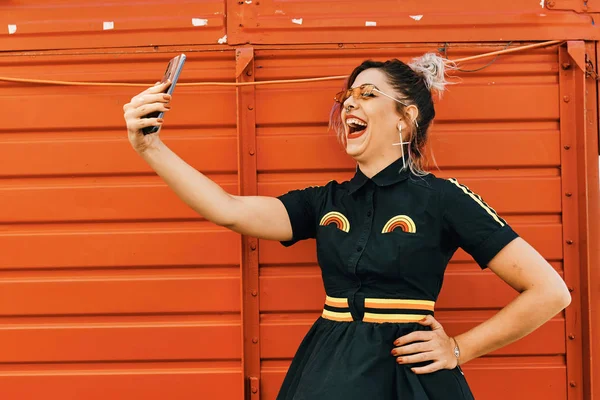 Jeune modèle avec look alternatif prendre selfie et rire - concept de style de vie — Photo