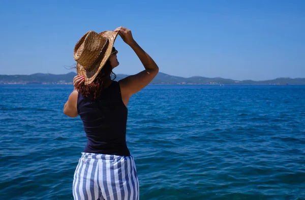 Egy fiatal nő kalappal az Adriai-tengeren-idegenforgalmi koncepció — Stock Fotó