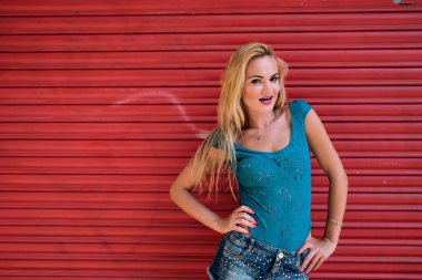 güçlü bir kırmızı arka plan ile genç bir kışkırtıcı kadın - ücretsiz renkler - jestler kavramı