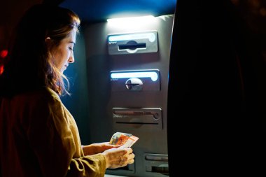 ATM 'den para çeken genç bir kadın.