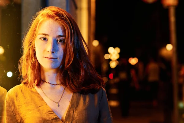 En ung kvinna på natten med färg ljus — Stockfoto