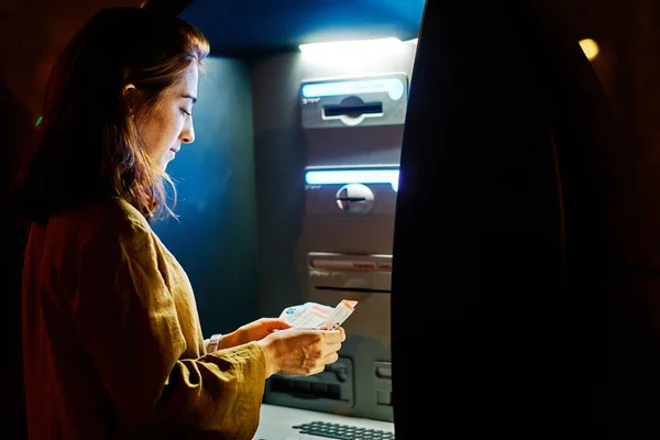 ATM 'den para çeken genç bir kadın.