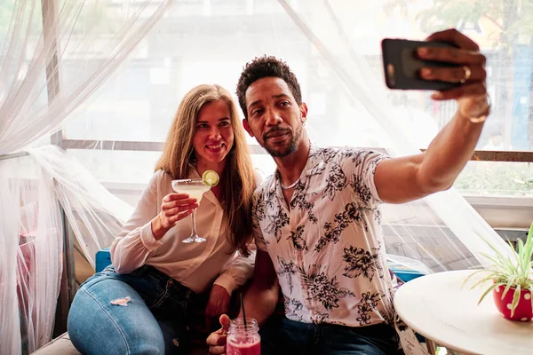 Joven interracial pareja en amor tomando selfie en el bar — Foto de Stock