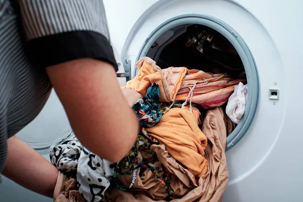 Крупним планом руки покласти одяг в пральну машину — стокове фото