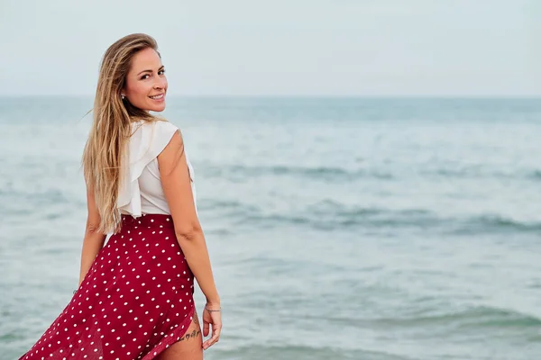 Jeune femme seule face à la mer par une journée d'été nuageuse — Photo