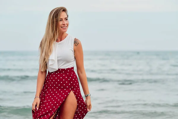 Giovane donna sola di fronte al mare in una giornata estiva nuvolosa — Foto Stock