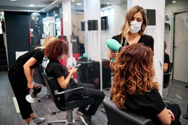 Kobiety w salonie piękności z dystansem społecznym i maskami ochronnymi — Zdjęcie stockowe