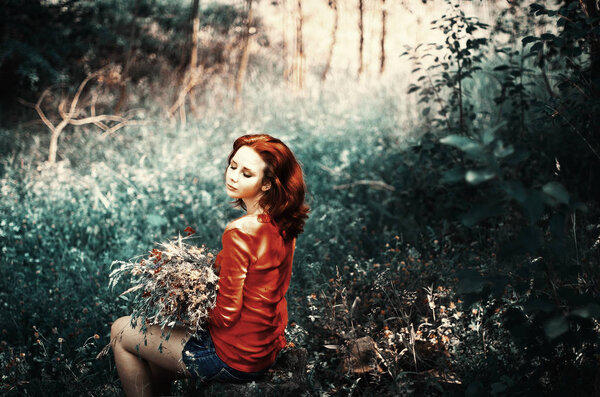 Charming red-haired girl.forest walk