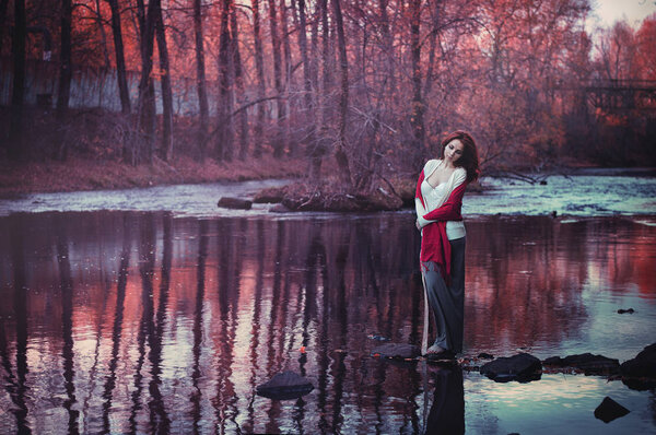 Girl in the autumn forest. fairy-tale reflection in the lake