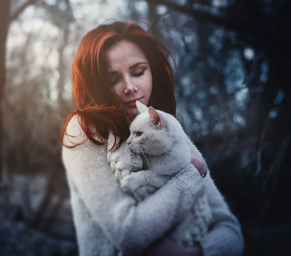 女孩在树林里与她的白猫 免版税图库图片
