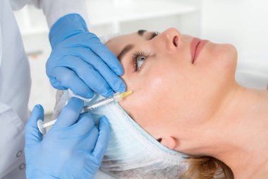 Doktor güzellik uzmanı sıkma ve bir güzellik salonu kadınlarda yüz cilt kırışıklıkları yumuşatma için gençleştirici yüz enjeksiyonları yordam bulunur. Kozmetik Cilt Bakımı.
